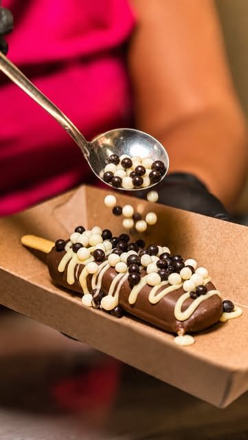 Picolé gourmet recebendo pérolas de chocolate