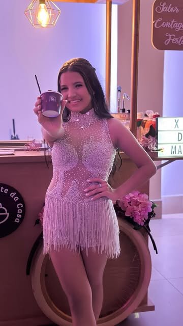 Debutante com açaí em frente ao carrinho nos 15 anos da Marianna
