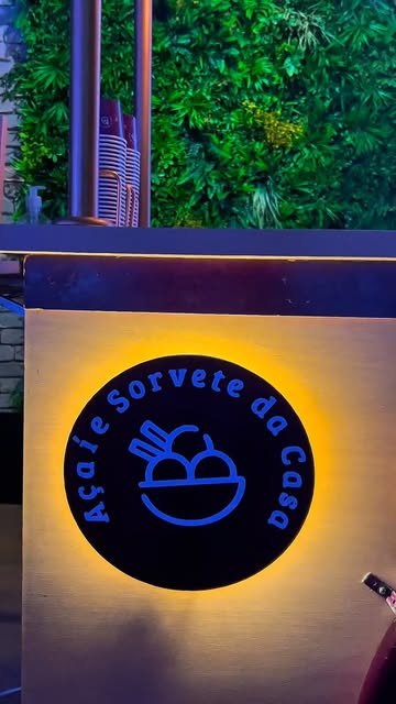 Letreiro iluminado com a logo da Açaí e Sorvete da Casa na Casa Bisutti